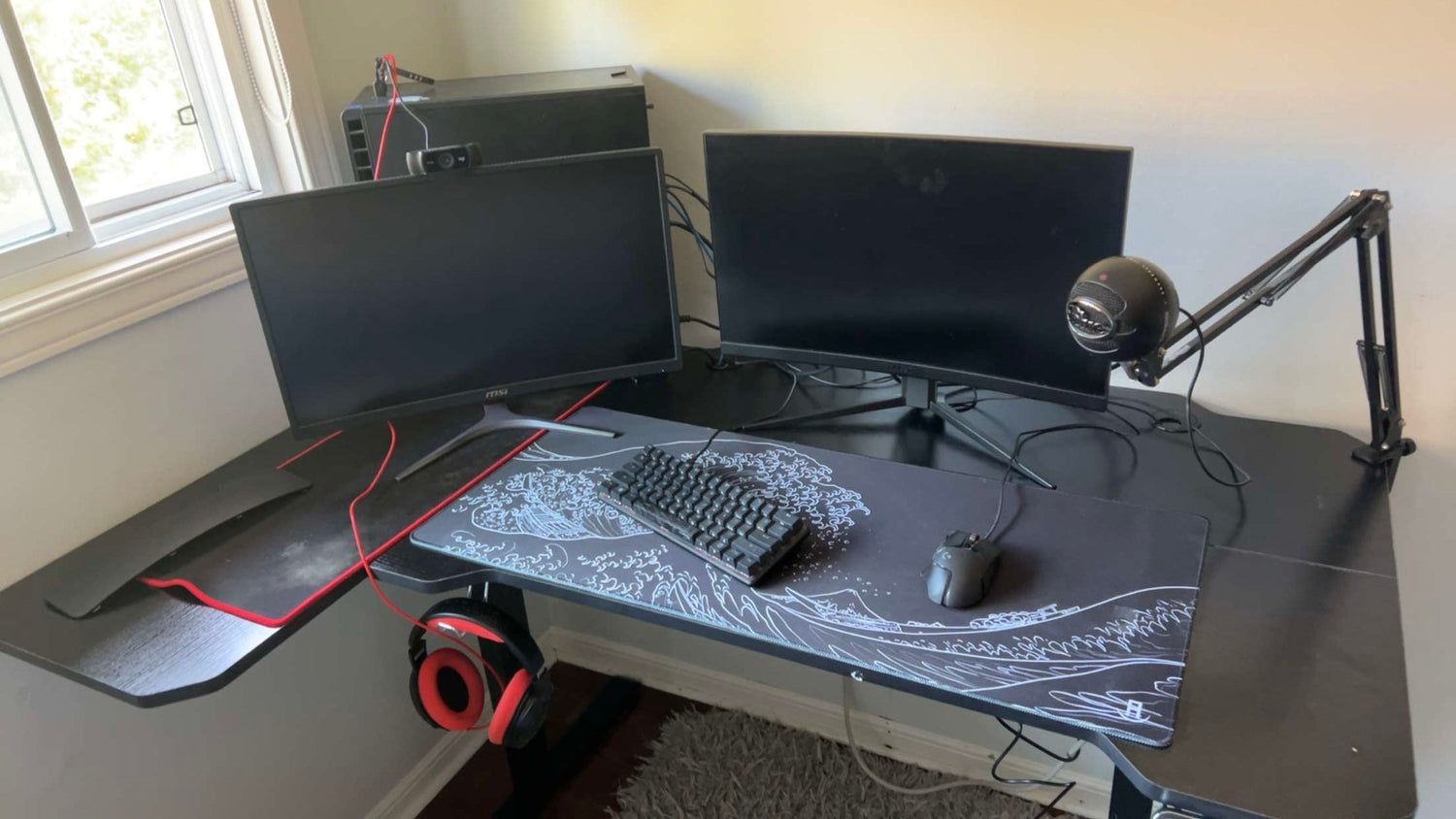 Black gaming setup with gaming gear and gaming computer and the black wave of kanagawa deskpad and mousepad