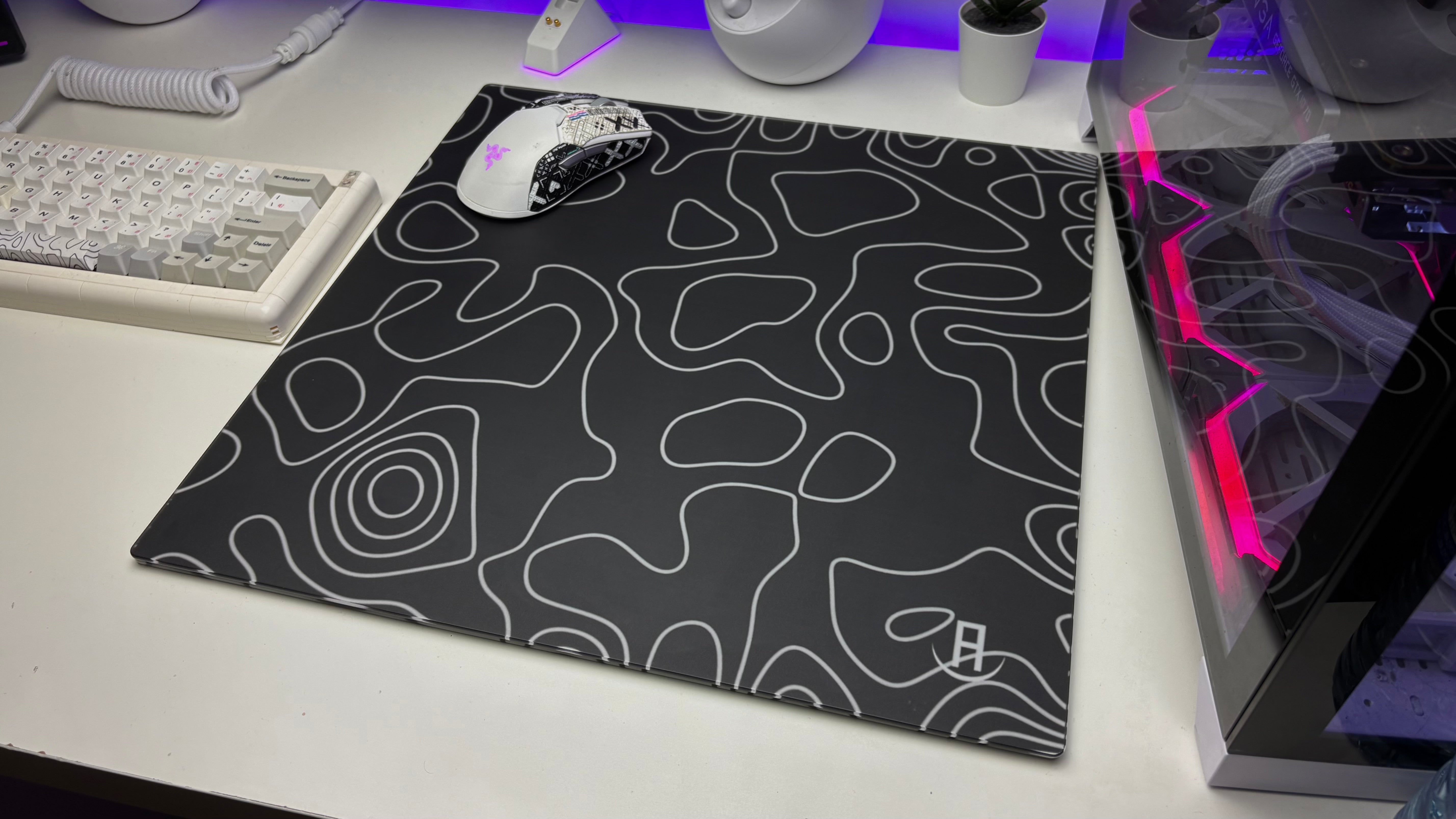 White topography glass mouse pad in a gaming setup with white gaming mouse on it