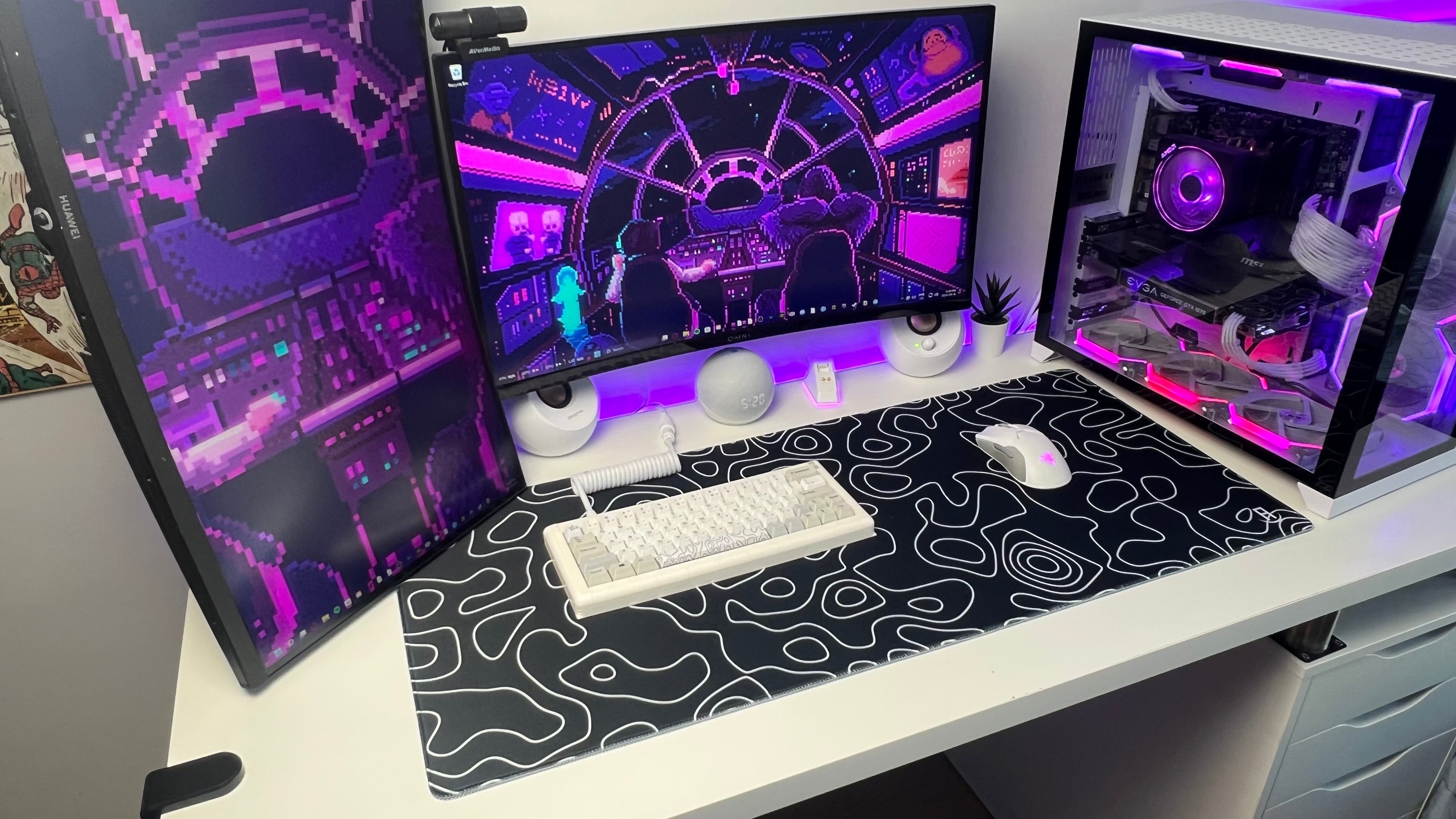 Computer setup with multiple monitors on a desk, featuring a black and white patterned mouse pad. Black topography desk pad side view from gaming setup.