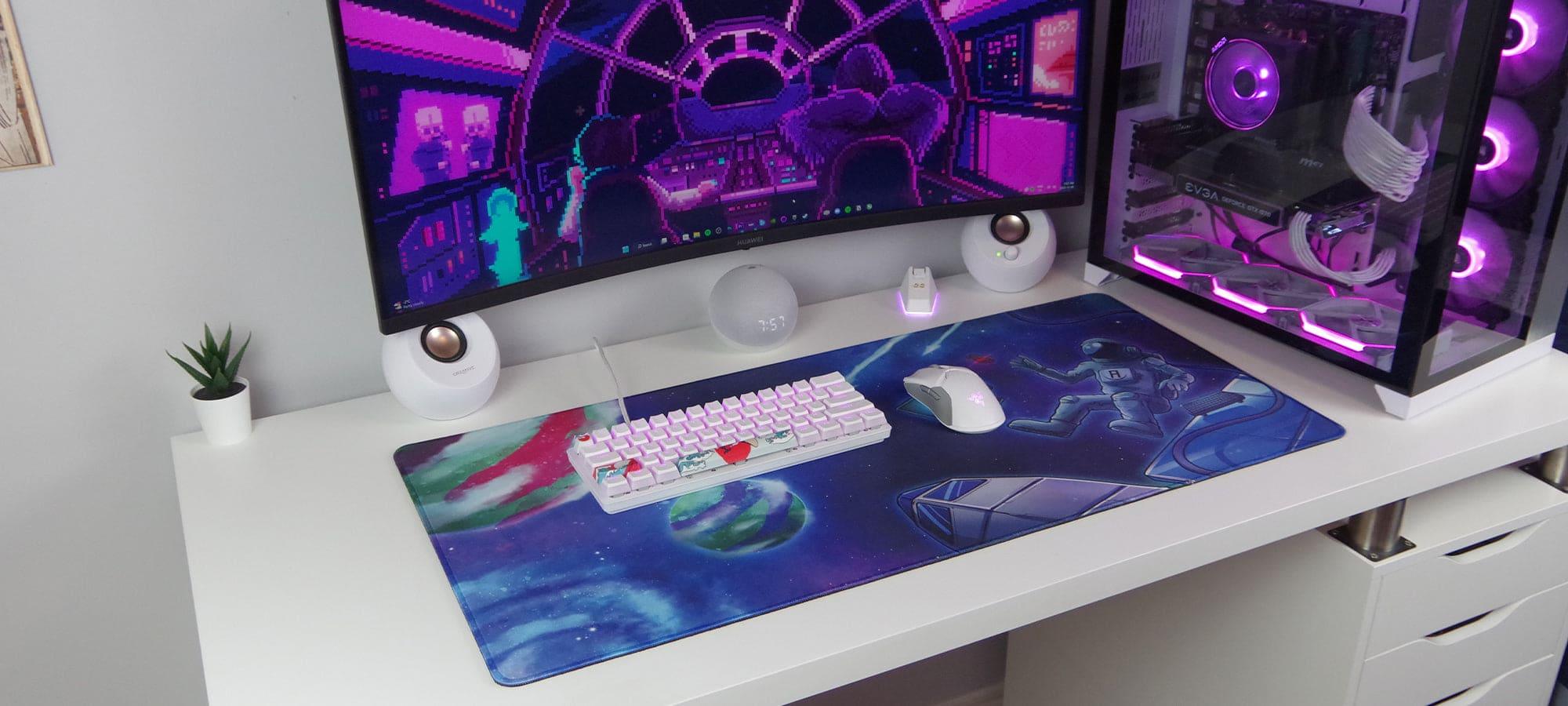 Space and astronaut with keyboard and mouse with planets in background deskpad and mousepad on desk 45 degree angle view