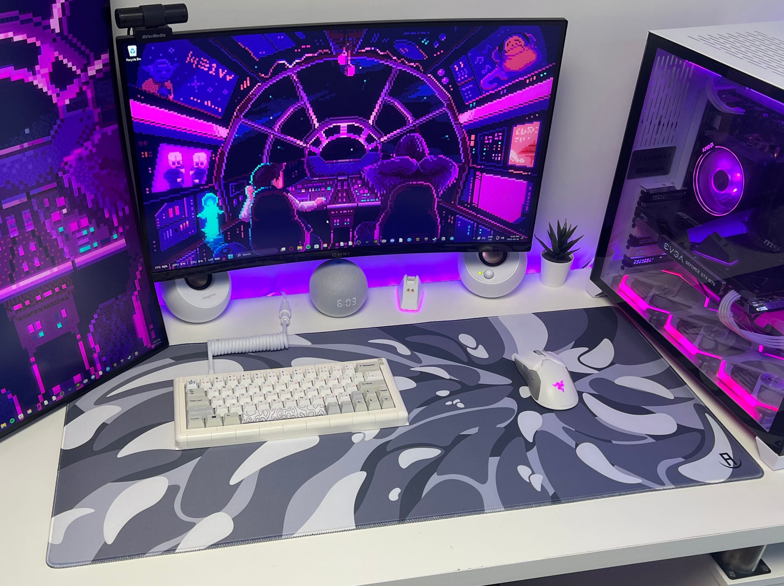 Computer setup with multiple monitors on a desk and front view of gaming setup with black and white swirl gaming mouse pad with gaming keyboard and gaming mouse on mouse pad